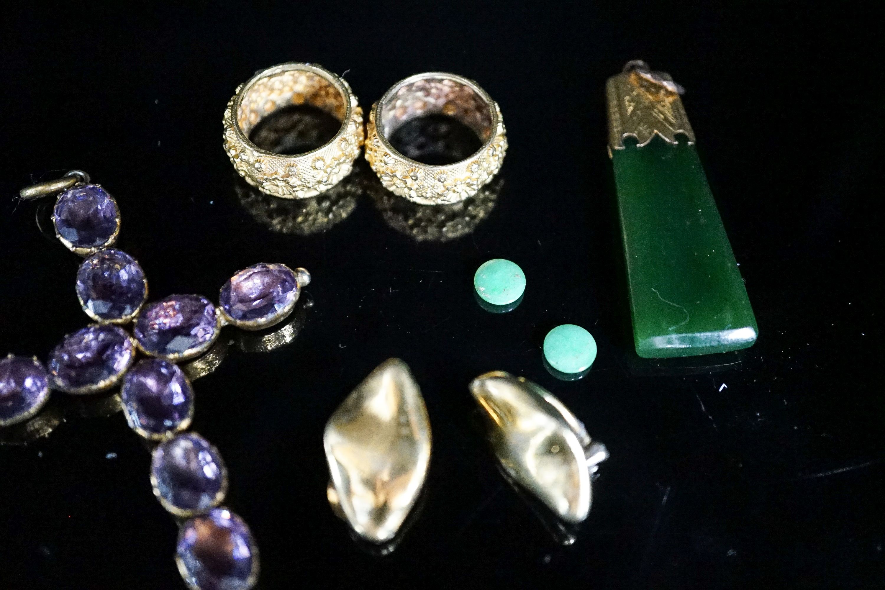 A Victorian gilt metal and foil backed amethyst paste set cross pendant, 67mm, a yellow metal mounted jade pendant and five other items.